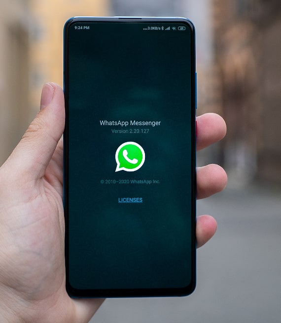 Mano stringe smartphone con Whatsapp Messenger sullo schermo