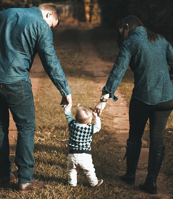 Mamma e papà insegnano bambino a camminare