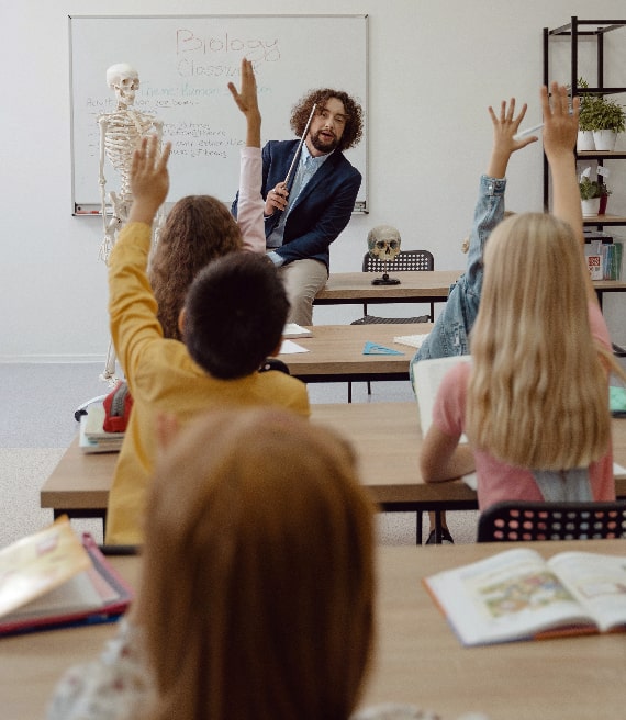 Professore biologia interroga bambini mani alzate